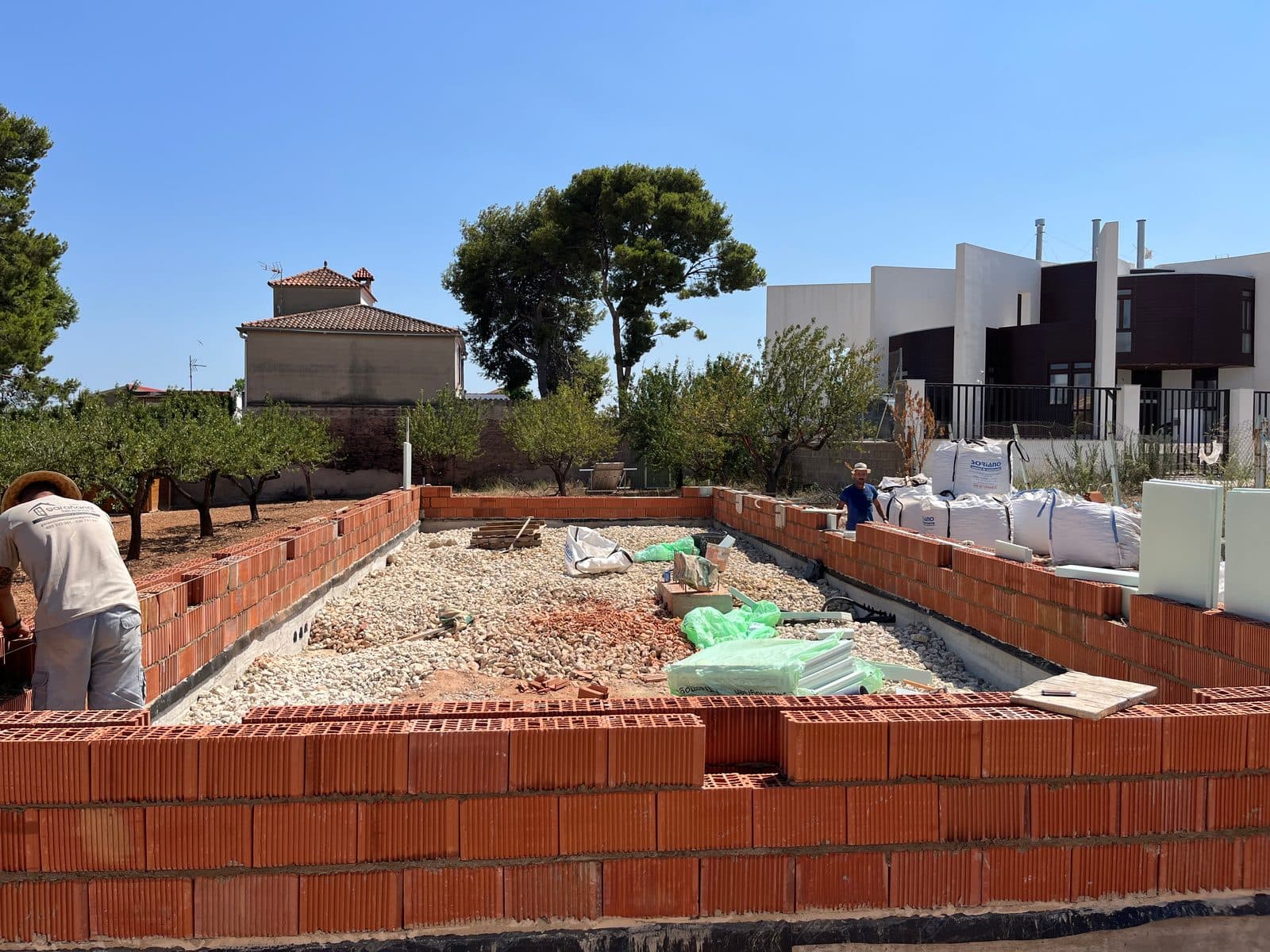 Primeras hiladas de ladrillo sobre la losa de una vivienda en obra